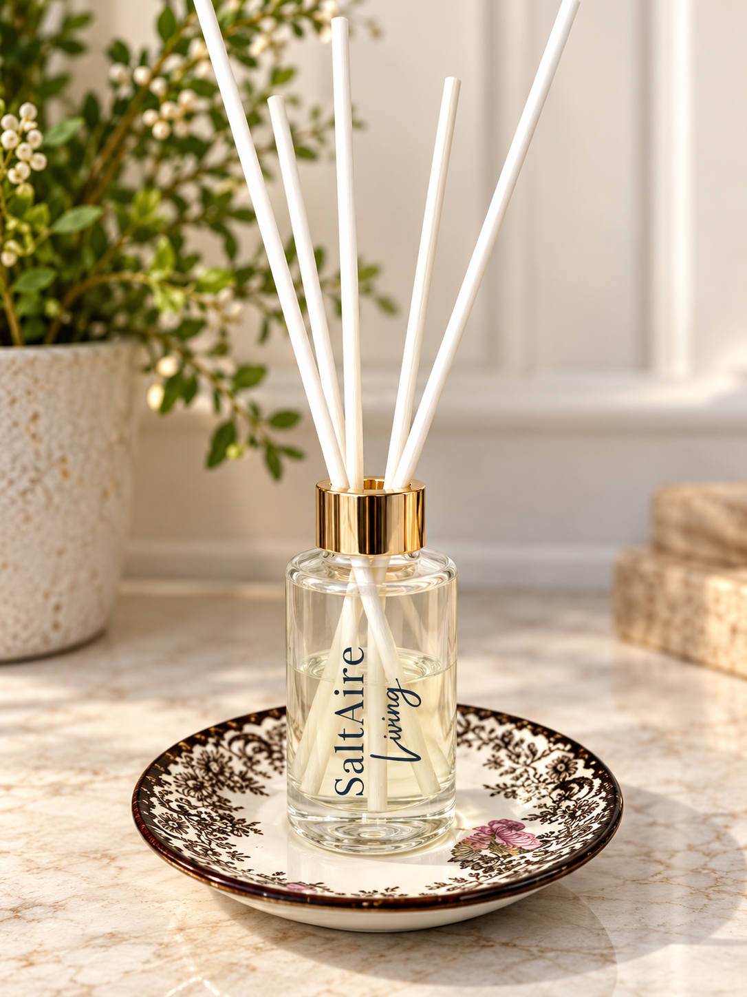 SaltAire Living reed diffuser on vintage floral dish